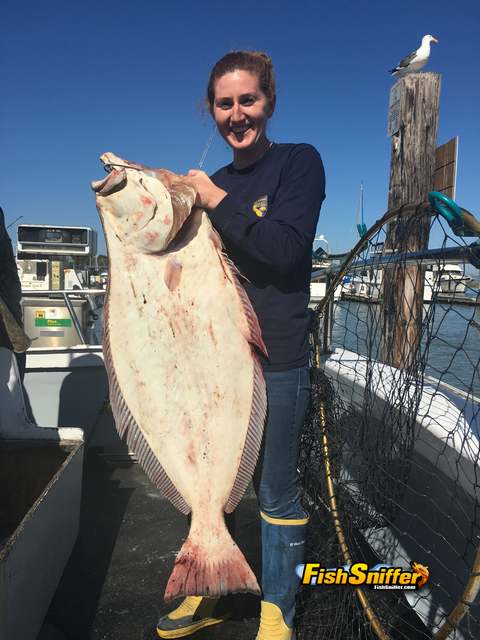 Kristine Leysna holds up a hefty halibut caught by Terry Gorr on San Francisco Bay aboard the Morning Star.
