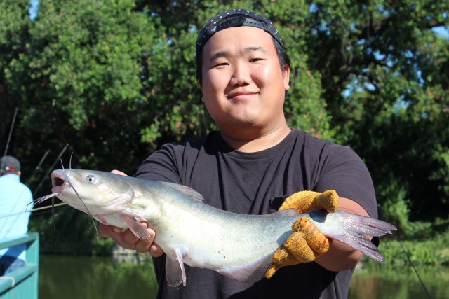 Daniel Vang holds up a channel catfish just caught out of the Howe Community Park Pond on July 1, Free Fishing Day.