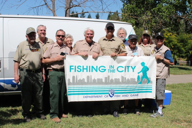 Joe Ferreira (center) and CDFW staff and volunteers for the Fishing in the City pose in front of the program’s van